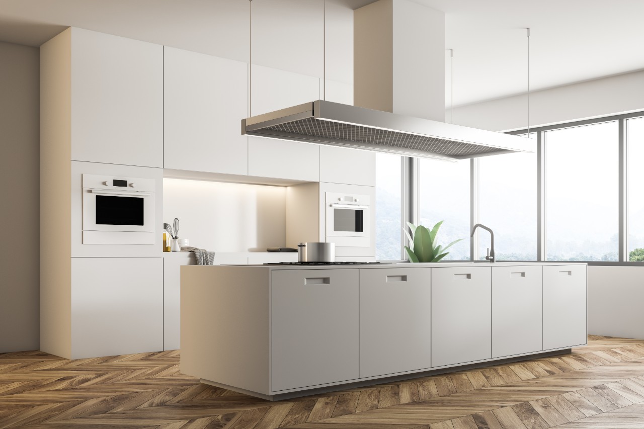 Corner of modern kitchen with white walls, wooden floor, large windows, and white island with built in appliances. 3d rendering mock up